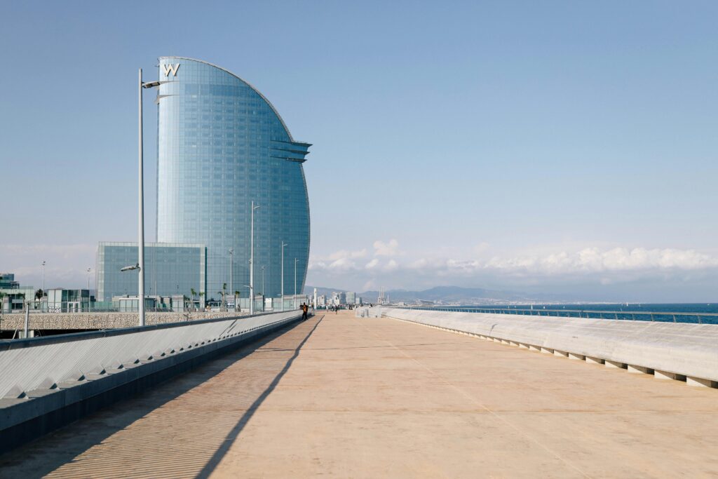 Iconic W Barcelona hotel with stunning design against a clear sky on a serene pier setting.